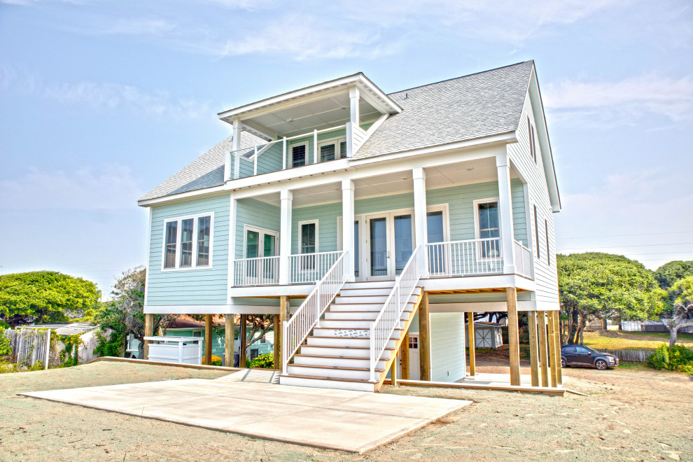Cette photo montre une grande façade de maison verte bord de mer à deux étages et plus avec un toit en shingle et un toit gris.