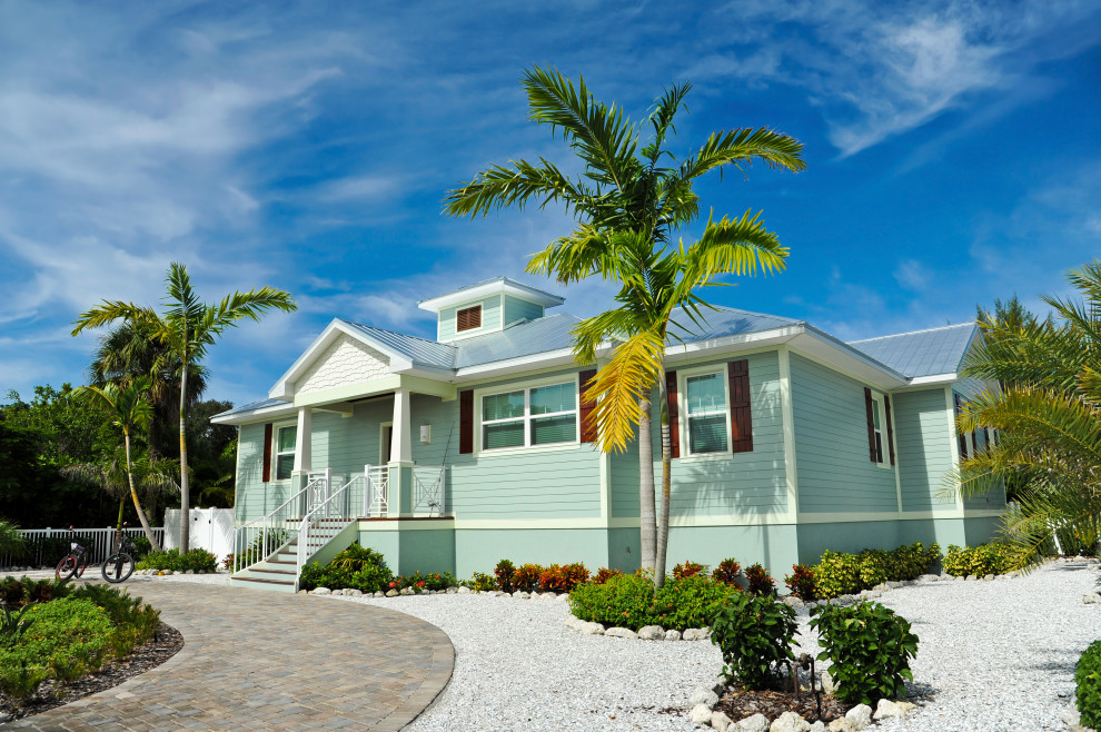 На фото: большой, одноэтажный, зеленый частный загородный дом в морском стиле с комбинированной облицовкой, двускатной крышей, крышей из смешанных материалов, синей крышей и отделкой доской с нащельником с