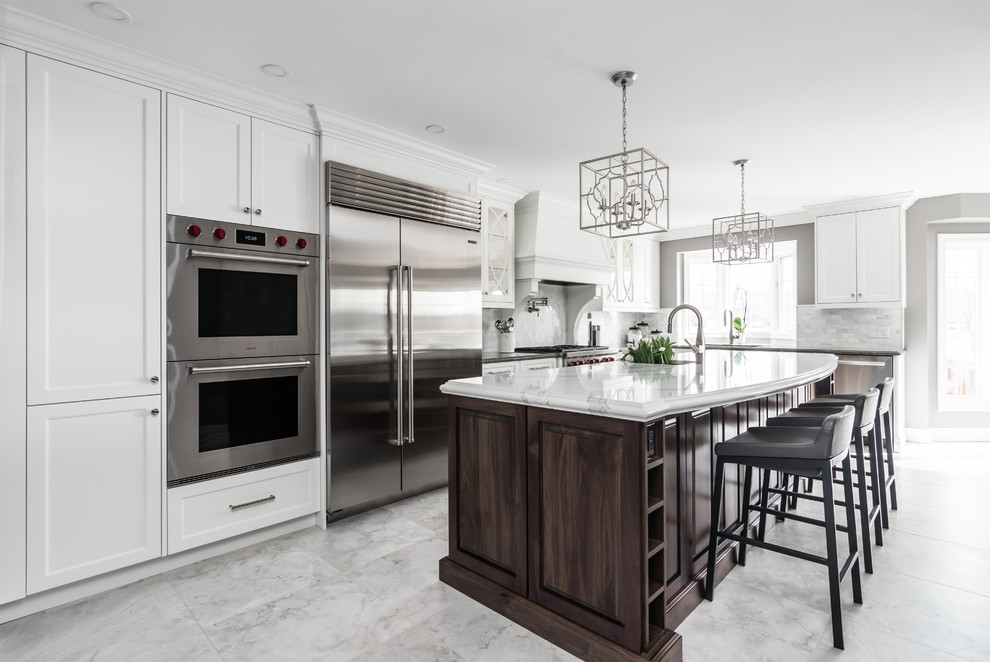 Example of a transitional l-shaped gray floor kitchen design in Toronto with recessed-panel cabinets, white cabinets, stainless steel appliances, an island and white countertops