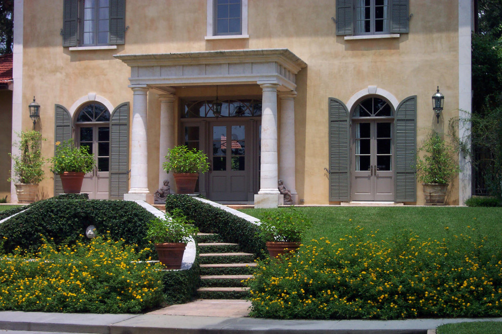 Design ideas for an expansive mediterranean two-storey stucco yellow exterior in New Orleans.