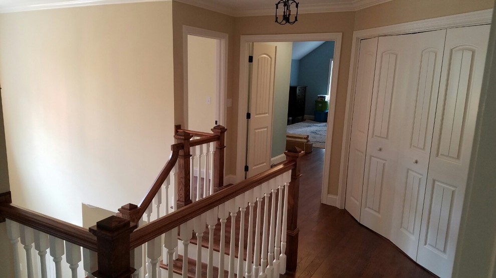 Example of a medium tone wood floor hallway design with beige walls