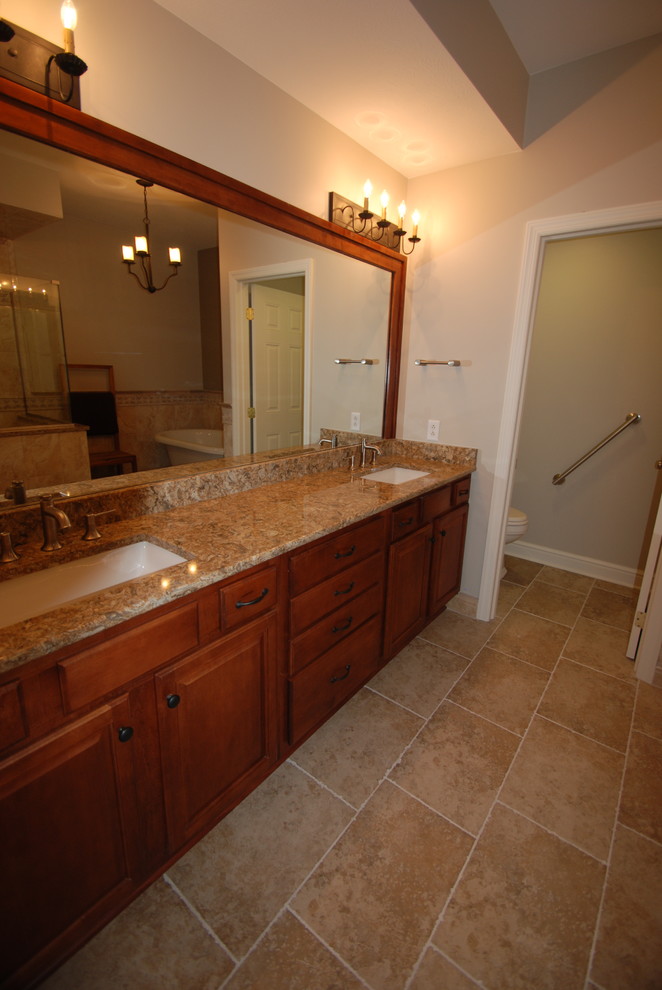 Transitional master freestanding bathtub photo with recessed-panel cabinets, medium tone wood cabinets, a drop-in sink and quartzite countertops