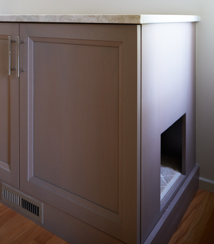 This is an example of a large contemporary gender-neutral walk-in wardrobe in Chicago with recessed-panel cabinets, medium wood cabinets, light hardwood floors and brown floor.