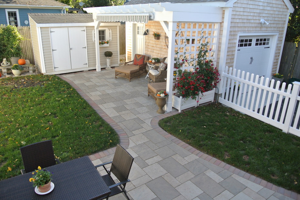Small mediterranean backyard patio in Providence with concrete pavers and an awning.
