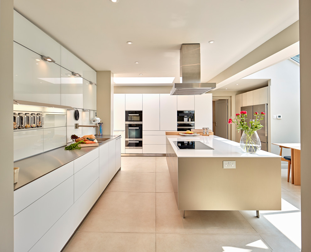 Contemporary l-shaped eat-in kitchen in Hampshire with a double-bowl sink, flat-panel cabinets, white cabinets, white splashback, with island, beige floor and white benchtop.