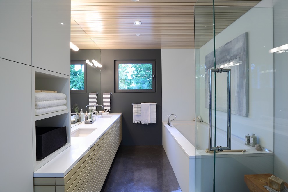 Photo of a mid-sized contemporary master bathroom in Vancouver with an undermount sink, engineered quartz benchtops, grey walls, concrete floors, flat-panel cabinets, beige cabinets, an alcove tub, a corner shower, brown floor and a hinged shower door.