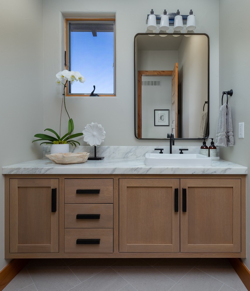 Design ideas for a transitional powder room in Denver with shaker cabinets, light wood cabinets, grey walls, a vessel sink, marble benchtops, grey floor and white benchtops.