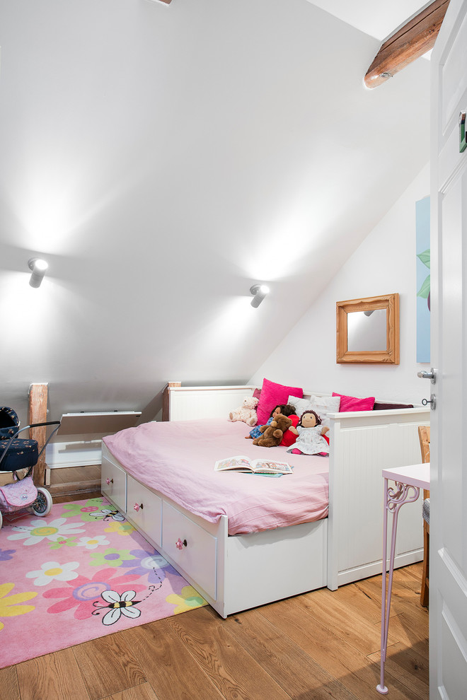 Photo of a mid-sized scandinavian kids' bedroom for kids 4-10 years old and girls in Malmo with white walls and medium hardwood floors.