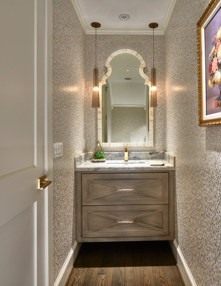 Inspiration for a transitional powder room in Dallas with beaded inset cabinets, grey cabinets, grey walls, dark hardwood floors, an undermount sink, brown floor, grey benchtops, a floating vanity and wallpaper.