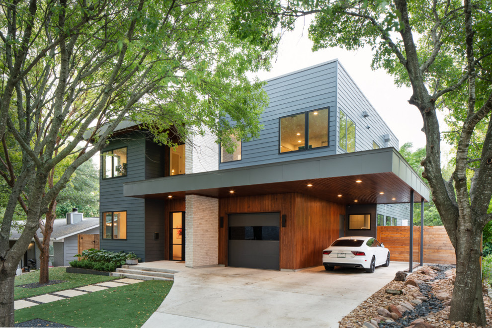 Kleines, Zweistöckiges Modernes Einfamilienhaus mit Backsteinfassade, grauer Fassadenfarbe, Schmetterlingsdach, Misch-Dachdeckung, grauem Dach und Verschalung in Austin