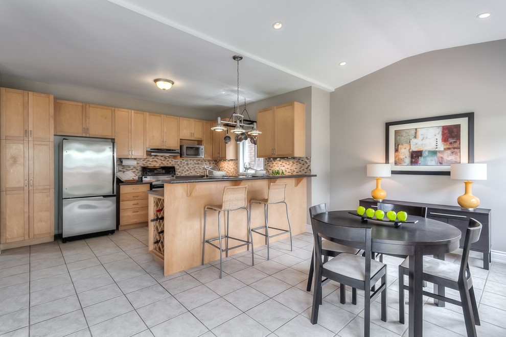 Example of a mid-sized transitional u-shaped ceramic tile eat-in kitchen design in Toronto with flat-panel cabinets, medium tone wood cabinets, laminate countertops, brown backsplash, glass tile backsplash, stainless steel appliances and an island