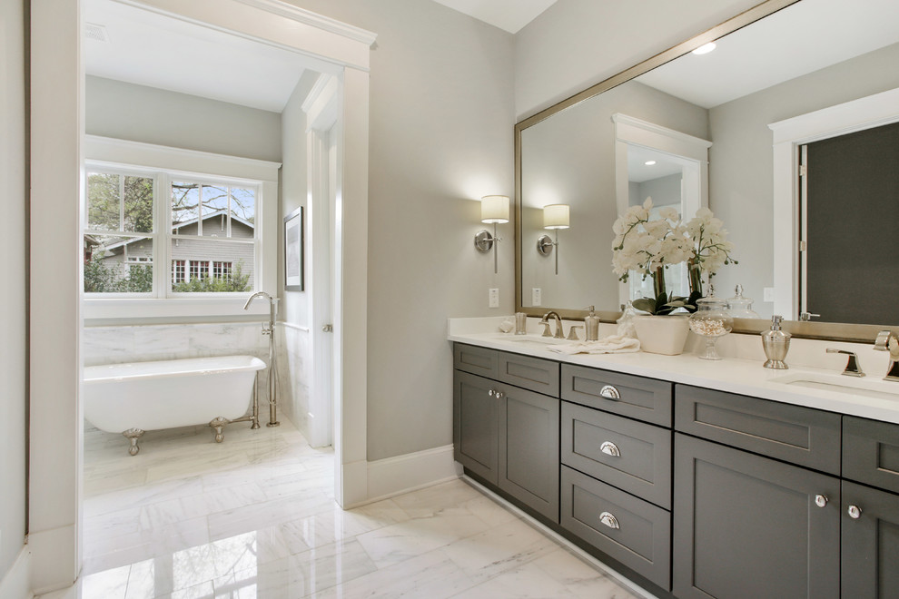 Photo of a mid-sized transitional master bathroom in Atlanta with grey cabinets, grey walls, shaker cabinets, a claw-foot tub, marble floors, an undermount sink and engineered quartz benchtops.