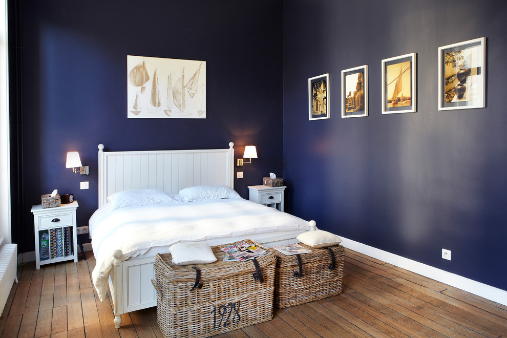 Design ideas for a mid-sized traditional master bedroom in Reims with blue walls and medium hardwood floors.