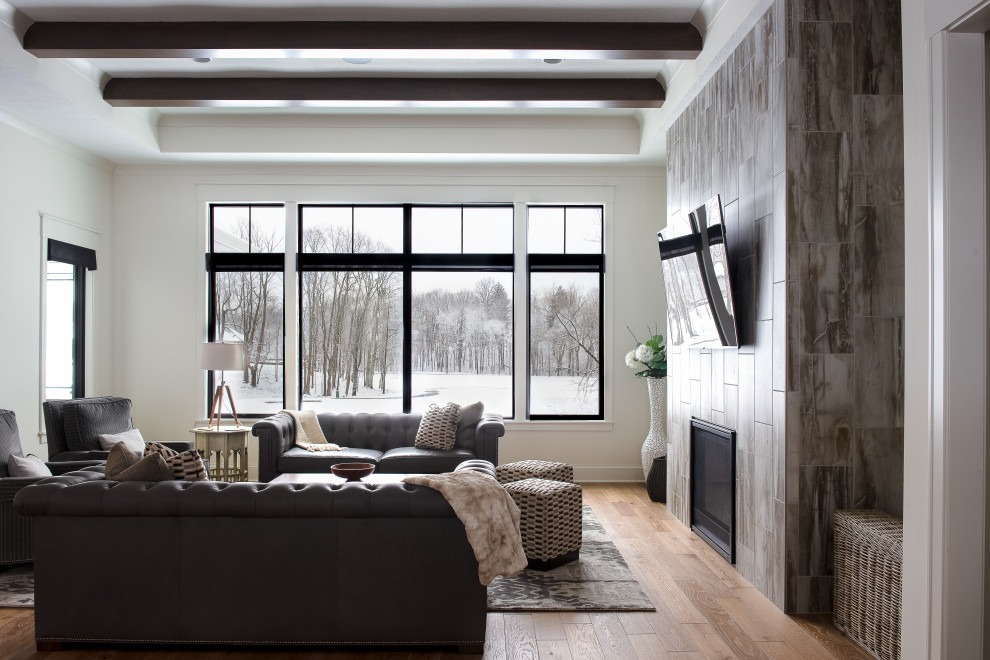 Inspiration for a mid-sized transitional formal enclosed living room in Indianapolis with beige walls, medium hardwood floors, a standard fireplace, a metal fireplace surround and a wall-mounted tv.