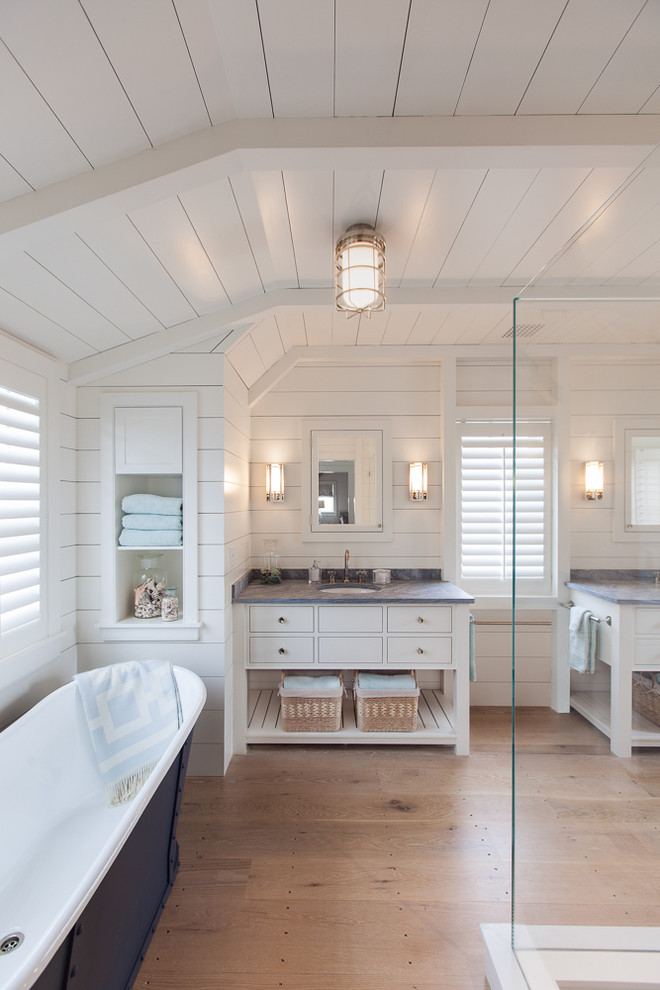 Example of a large beach style master white tile and ceramic tile light wood floor bathroom design in Boston with white cabinets, granite countertops, white walls, an undermount sink and flat-panel cabinets