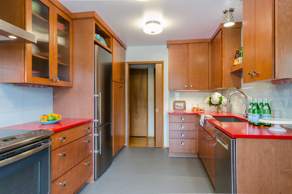 Design ideas for a mid-sized midcentury galley separate kitchen in Seattle with a single-bowl sink, flat-panel cabinets, medium wood cabinets, quartz benchtops, glass tile splashback, stainless steel appliances, vinyl floors, no island and white splashback.