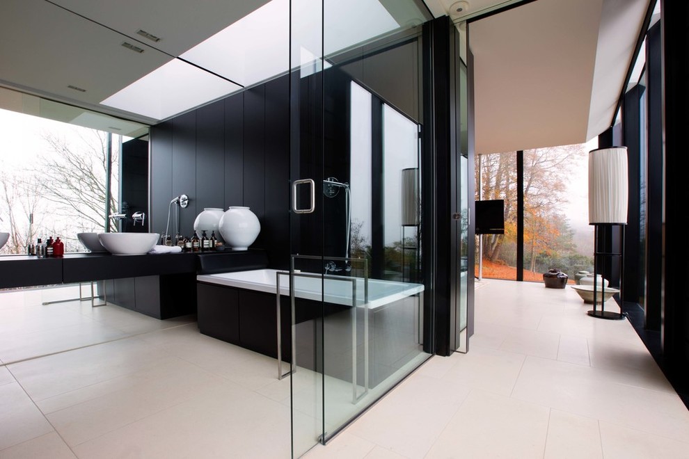 Inspiration for a large contemporary master bathroom in London with a drop-in tub, black walls and a vessel sink.