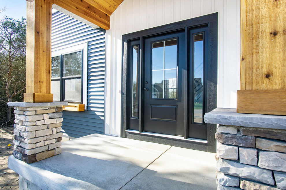 Photo of a mid-sized country front door in Grand Rapids with white walls, a single front door and a black front door.