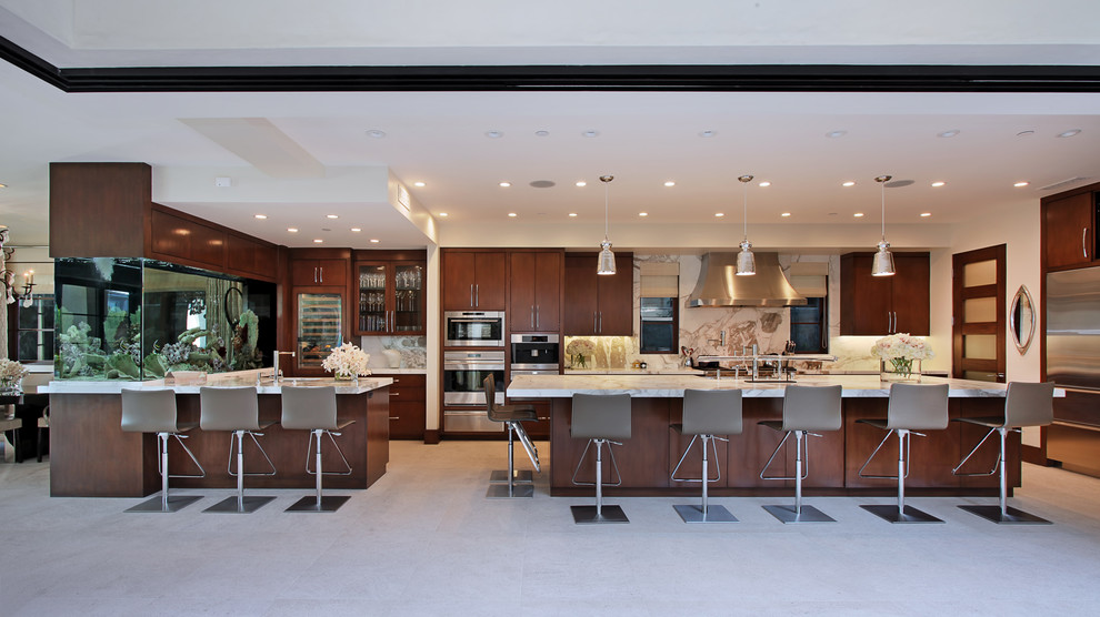 Inspiration for an expansive contemporary kitchen in Orange County with flat-panel cabinets, dark wood cabinets, marble benchtops, white splashback, stone slab splashback, stainless steel appliances, ceramic floors and with island.