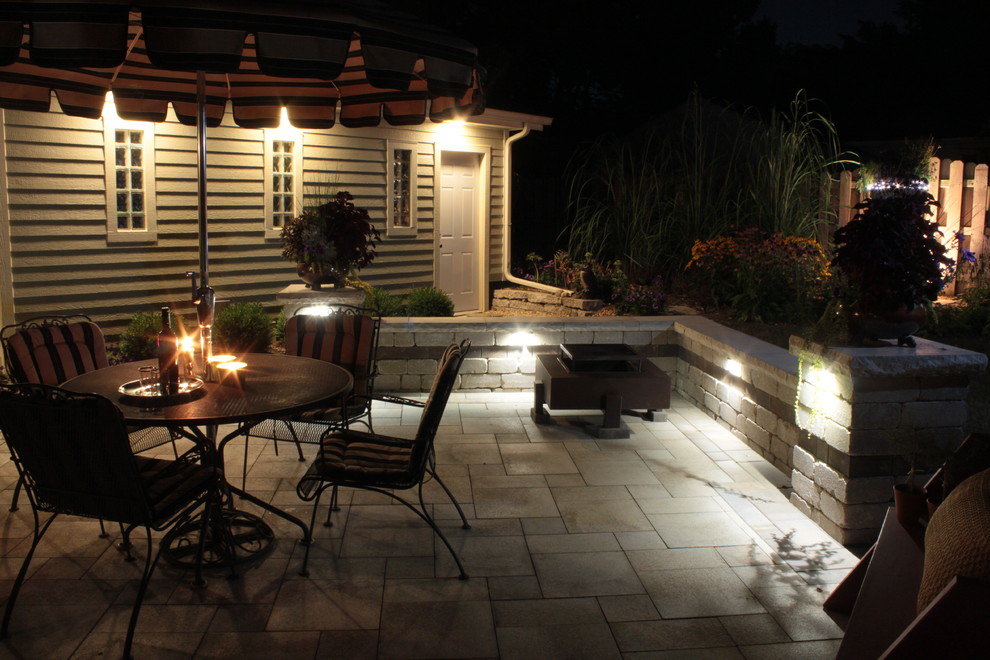 This is an example of a mid-sized traditional backyard patio in Milwaukee with natural stone pavers and a gazebo/cabana.