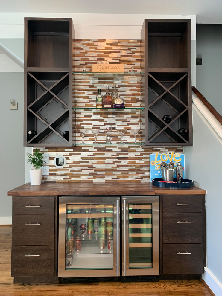 This is an example of a mid-sized modern single-wall wet bar in Houston with flat-panel cabinets, dark wood cabinets, wood benchtops, multi-coloured splashback, metal splashback and brown benchtop.