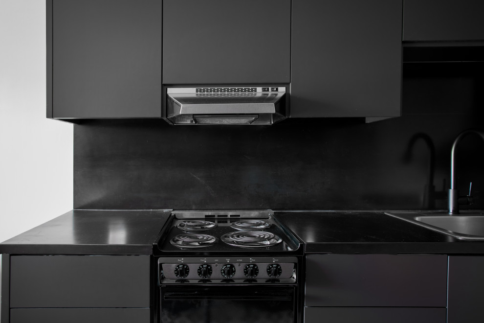 This is an example of a small modern single-wall eat-in kitchen in Austin with ceramic floors, black floor, recessed, an undermount sink, flat-panel cabinets, black cabinets, copper benchtops, black splashback, black appliances, no island and black benchtop.