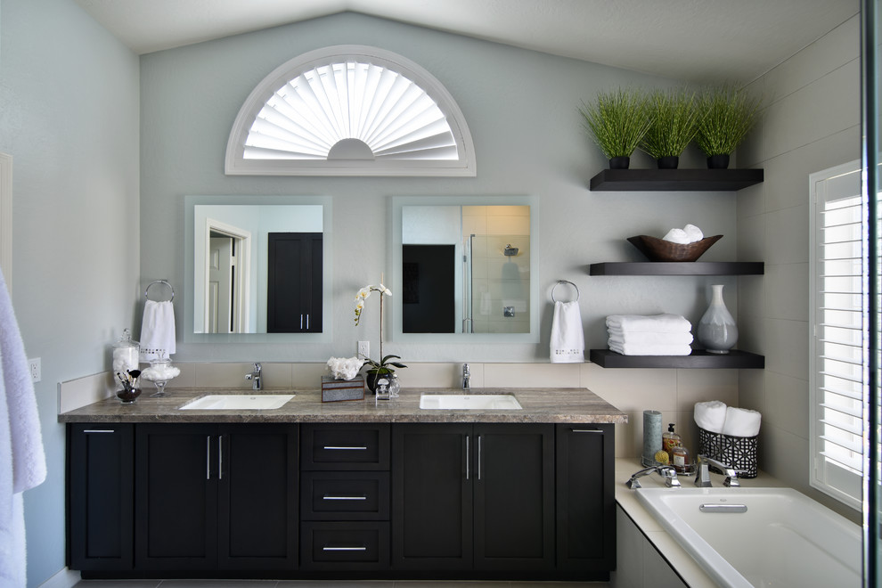 Drop-in bathtub - mid-sized transitional master white tile drop-in bathtub idea in Phoenix with shaker cabinets, dark wood cabinets, a one-piece toilet, blue walls, an undermount sink and a hinged shower door