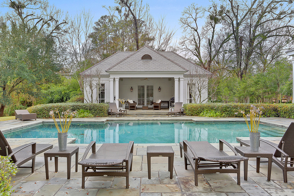 Inspiration for a mid-sized traditional backyard rectangular pool in New Orleans with a pool house and natural stone pavers.