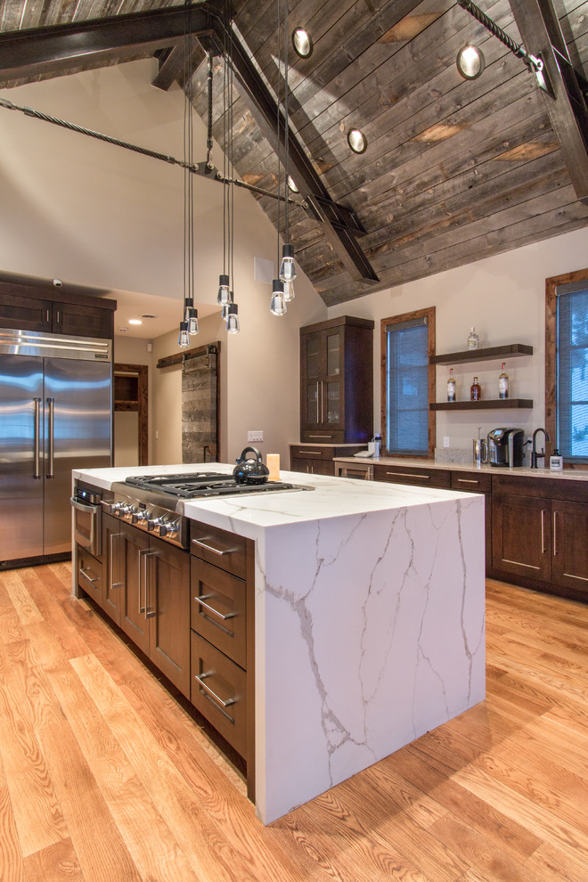 Inspiration for a large rustic u-shaped light wood floor and brown floor enclosed kitchen remodel in Denver with an undermount sink, shaker cabinets, dark wood cabinets, marble countertops, gray backsplash, mosaic tile backsplash, stainless steel appliances and an island