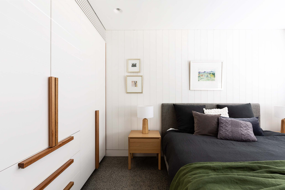 Modern inredning av ett sovrum, med vita väggar och grått golv