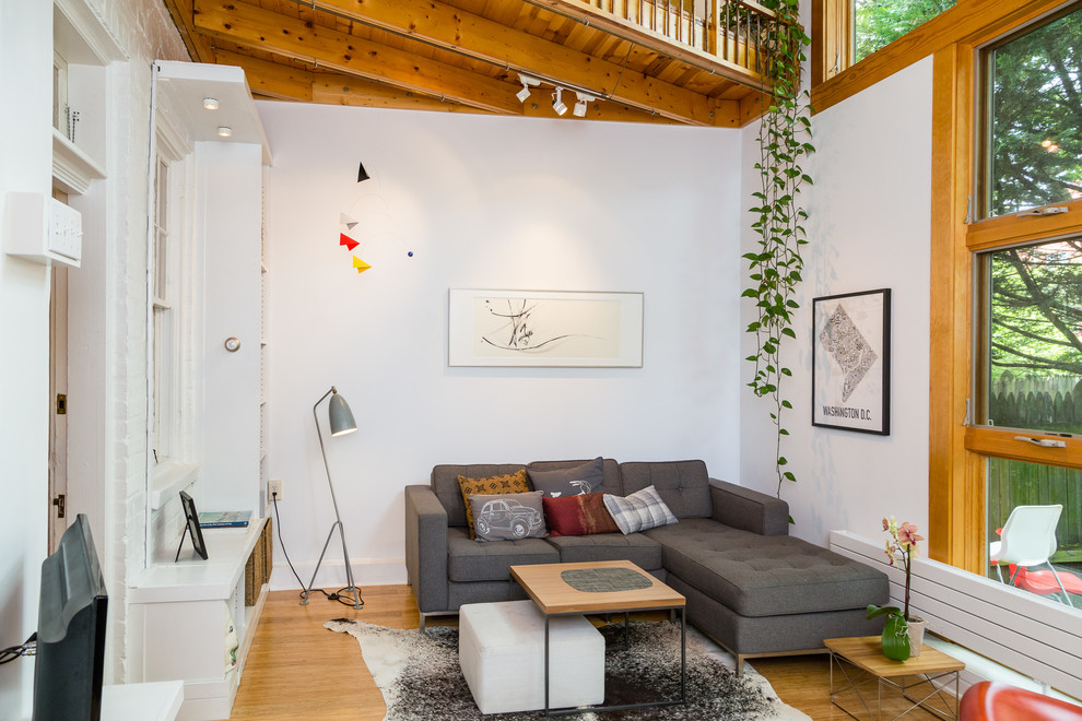 Family room - transitional medium tone wood floor family room idea in DC Metro with white walls