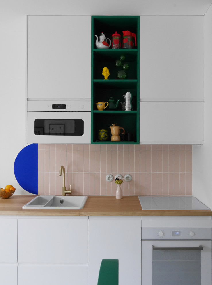 Inspiration for a small modern single-wall open plan kitchen in Paris with a drop-in sink, beaded inset cabinets, blue cabinets, laminate benchtops, pink splashback, porcelain splashback, white appliances and beige benchtop.
