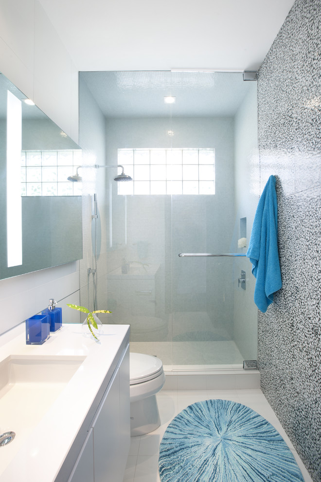 Photo of a contemporary bathroom in Miami with an undermount sink, flat-panel cabinets, white cabinets, an alcove shower and multi-coloured tile.
