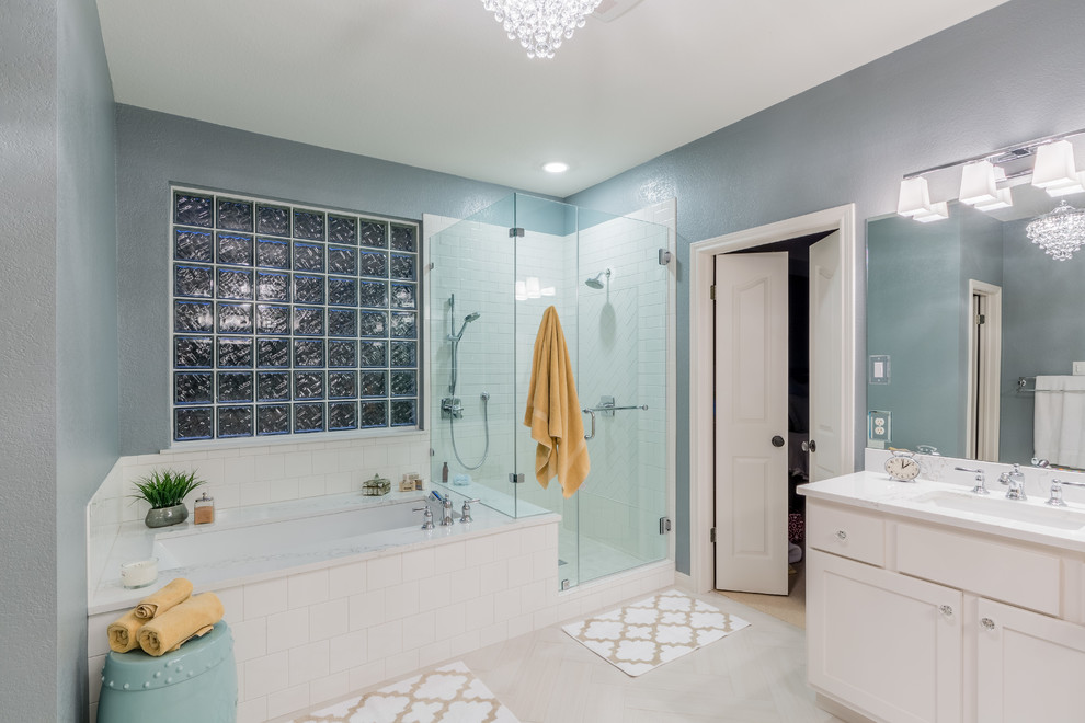 Mid-sized transitional master bathroom in Austin with shaker cabinets, white cabinets, an undermount tub, a corner shower, white tile, ceramic tile, grey walls, porcelain floors, an undermount sink and engineered quartz benchtops.