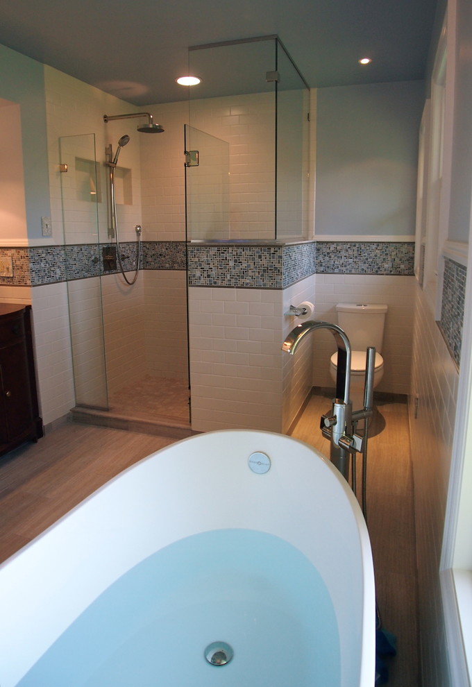 Large transitional blue tile porcelain tile freestanding bathtub photo with a vessel sink, wood countertops, a one-piece toilet and blue walls