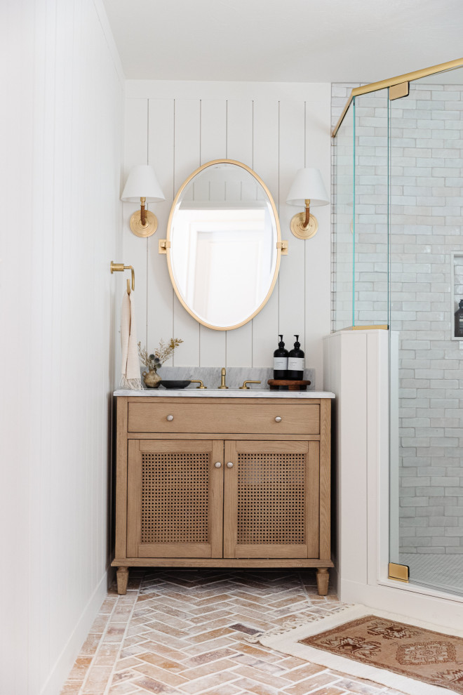 Mid-sized transitional white tile and terra-cotta tile brick floor, red floor, single-sink and shiplap wall corner shower photo in Orlando with light wood cabinets, a two-piece toilet, white walls, marble countertops, a hinged shower door, gray countertops and a freestanding vanity