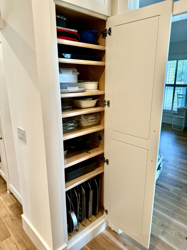 Inspiration for a mid-sized transitional l-shaped light wood floor, brown floor and wallpaper ceiling eat-in kitchen remodel in Atlanta with a farmhouse sink, shaker cabinets, white cabinets, granite countertops, white backsplash, stainless steel appliances, an island and white countertops