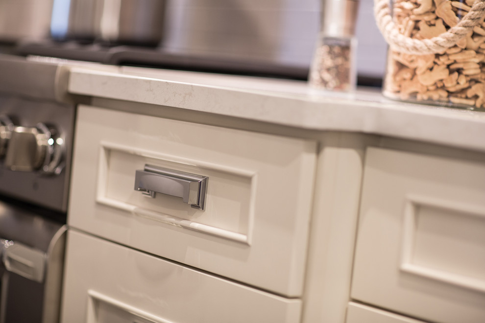 Inspiration for a large transitional l-shaped dark wood floor, brown floor and vaulted ceiling eat-in kitchen remodel in Chicago with a farmhouse sink, white cabinets, quartzite countertops, white backsplash, subway tile backsplash, stainless steel appliances, gray walls, shaker cabinets, an island and white countertops