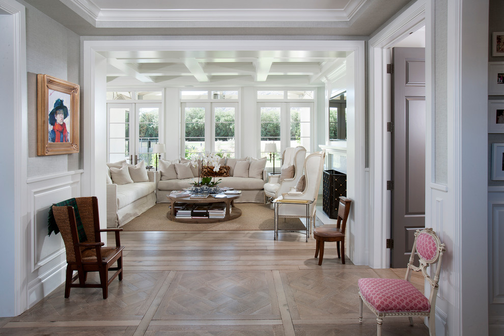 Photo of an open concept living room in Los Angeles with white walls and light hardwood floors.