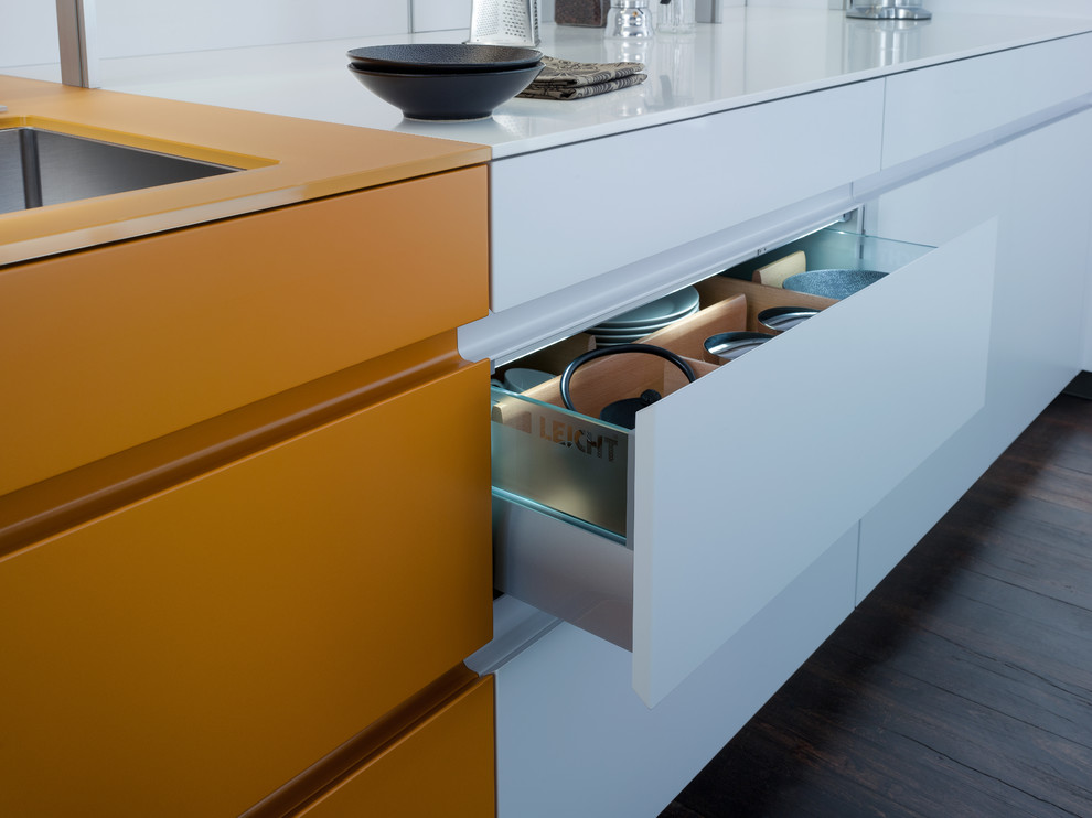 Large u-shaped eat-in kitchen in Orange County with an undermount sink, flat-panel cabinets, orange cabinets, quartz benchtops, white splashback, panelled appliances and dark hardwood floors.