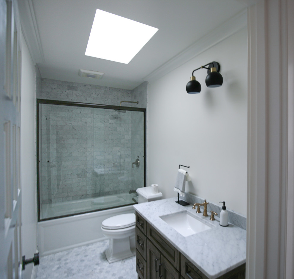 Inredning av ett rustikt mellanstort grå grått badrum, med skåp i shakerstil, skåp i mörkt trä, ett badkar i en alkov, en dusch i en alkov, en toalettstol med hel cisternkåpa, grå kakel, marmorkakel, vita väggar, marmorgolv, ett nedsänkt handfat, marmorbänkskiva, grått golv och dusch med skjutdörr