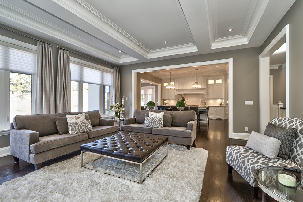Inspiration for a large contemporary enclosed family room in Toronto with grey walls, dark hardwood floors, a standard fireplace, a plaster fireplace surround and a wall-mounted tv.