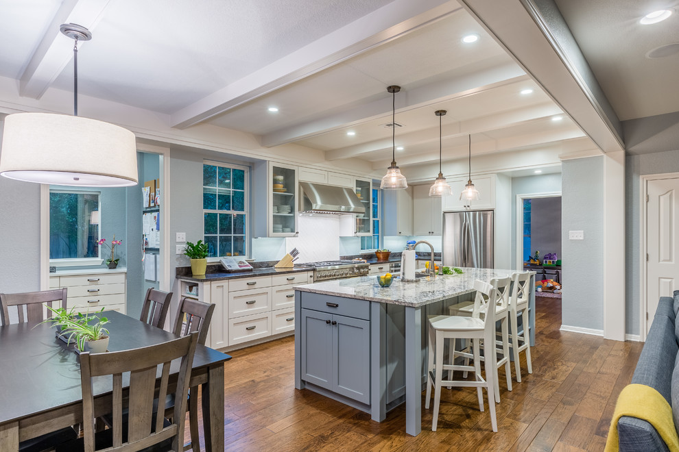Eat-in kitchen - mid-sized transitional l-shaped medium tone wood floor eat-in kitchen idea in Austin with an undermount sink, shaker cabinets, white cabinets, granite countertops, stainless steel appliances and an island