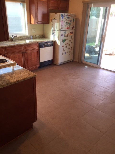 Example of a small transitional l-shaped ceramic tile eat-in kitchen design in Phoenix with an undermount sink, raised-panel cabinets, medium tone wood cabinets, granite countertops, white appliances and no island