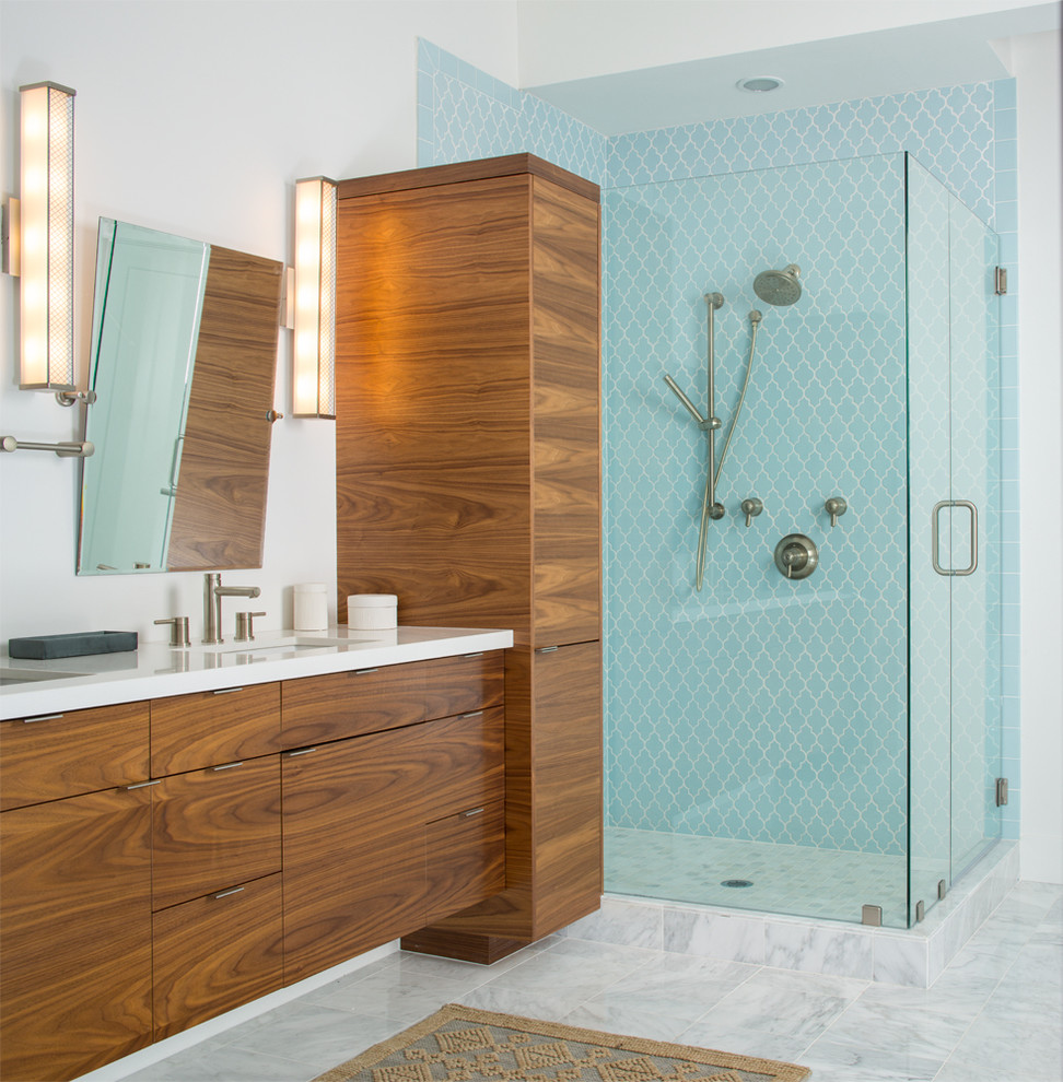 Photo of a contemporary bathroom in Salt Lake City with flat-panel cabinets, medium wood cabinets, a corner shower, blue tile, white walls, an undermount sink and a hinged shower door.