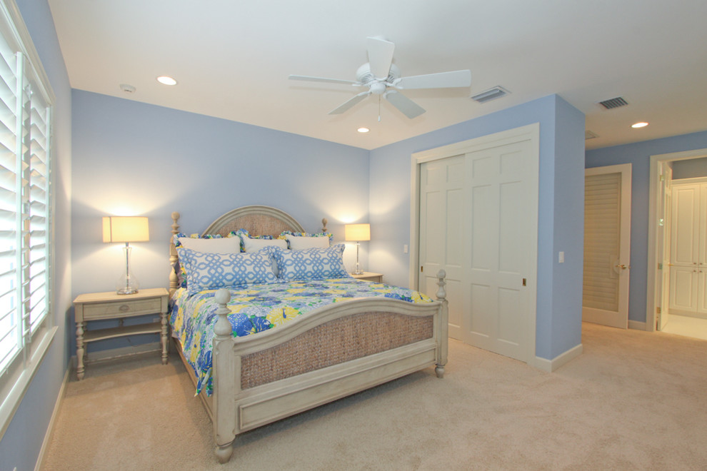 This is an example of a transitional guest bedroom in Miami with blue walls, carpet and beige floor.