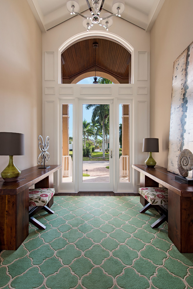 Photo of a mid-sized transitional foyer in Miami with beige walls, carpet, a single front door, a glass front door and brown floor.