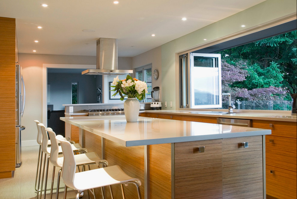 Example of a mid-sized transitional u-shaped concrete floor eat-in kitchen design in Vancouver with a drop-in sink, flat-panel cabinets, medium tone wood cabinets, laminate countertops, gray backsplash, custom tile backsplash, white appliances, gray walls and an island
