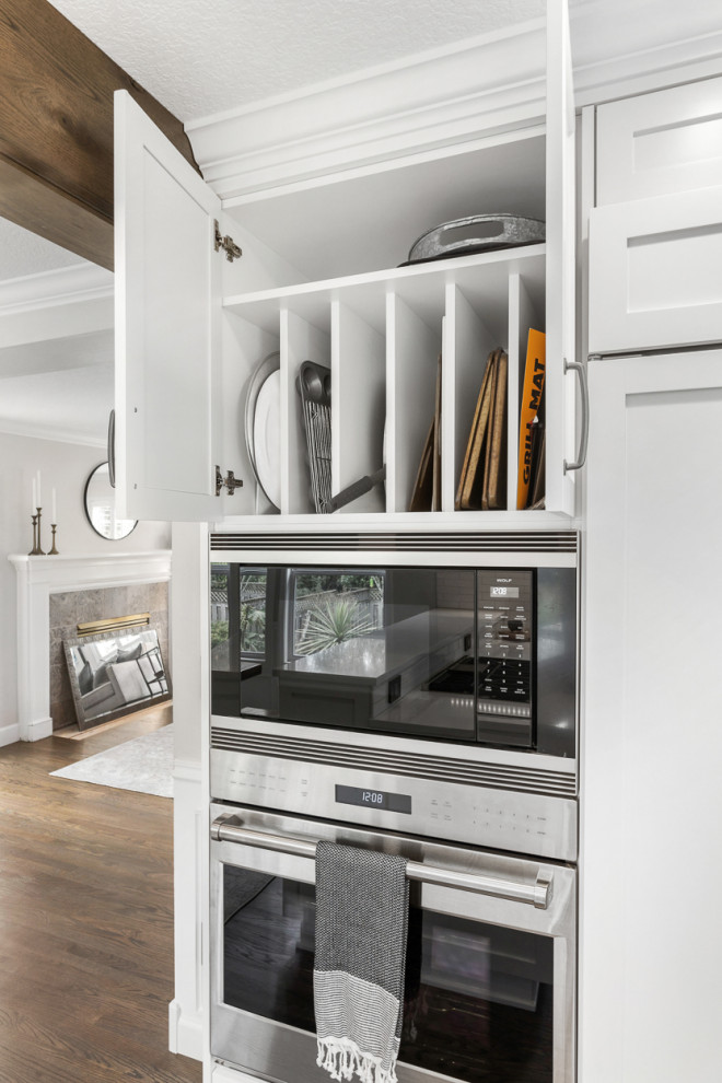 ポートランドにある高級なトラディショナルスタイルのおしゃれなアイランドキッチン (シェーカースタイル扉のキャビネット、珪岩カウンター、白いキッチンパネル、シルバーの調理設備、白いキッチンカウンター) の写真