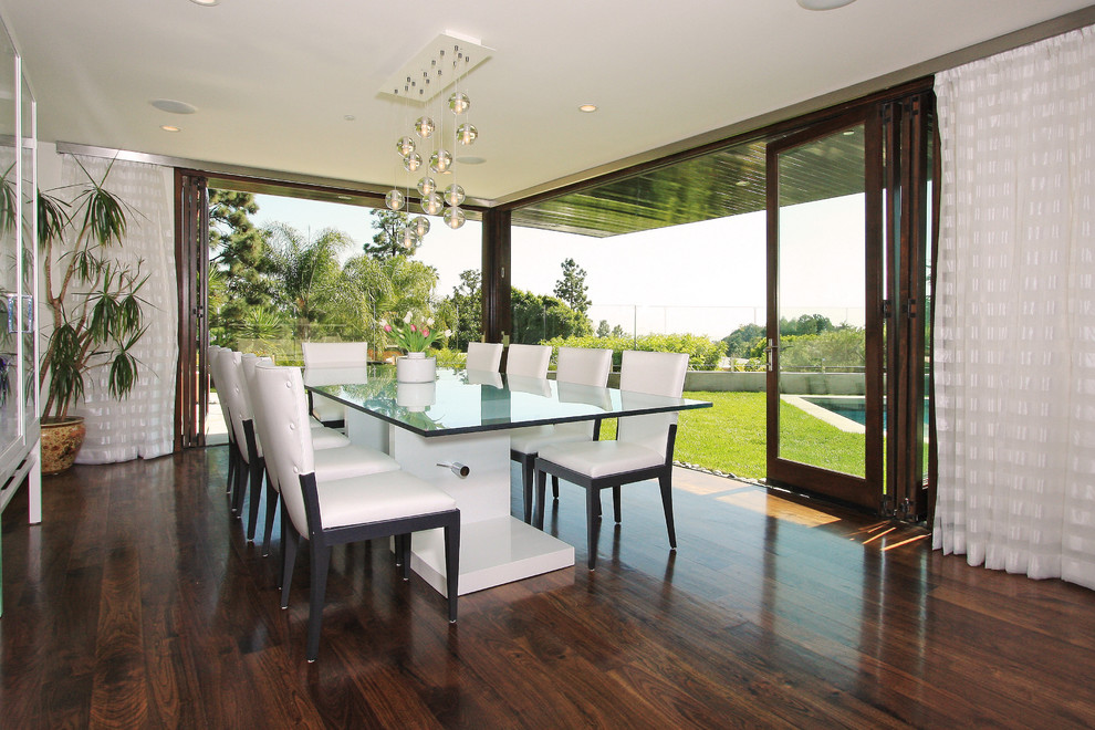 This is an example of a contemporary dining room in Los Angeles with white walls and dark hardwood floors.